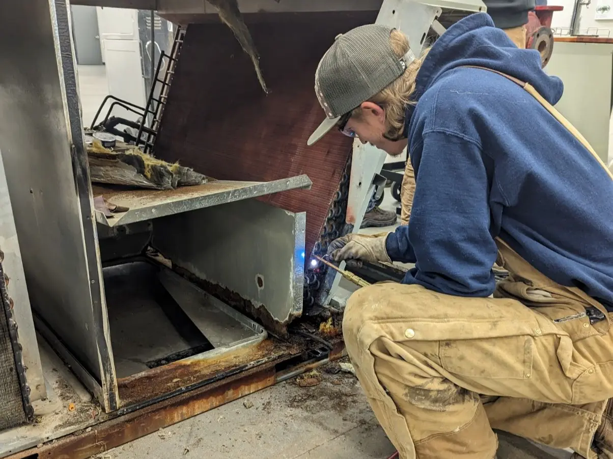 Student using a welding tool