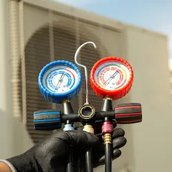 Hand holding HVAC gauges