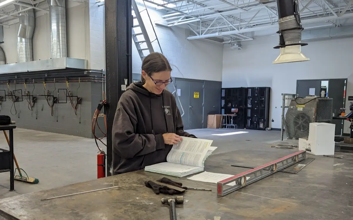 Smiling woman reading a manual in a facility building